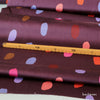 detail-foto-mit-massstock-vom-baumwollsatin-stoff-spots-dark-purple-mit-farbklecksen-in-pink-orange-lila-rost-braun