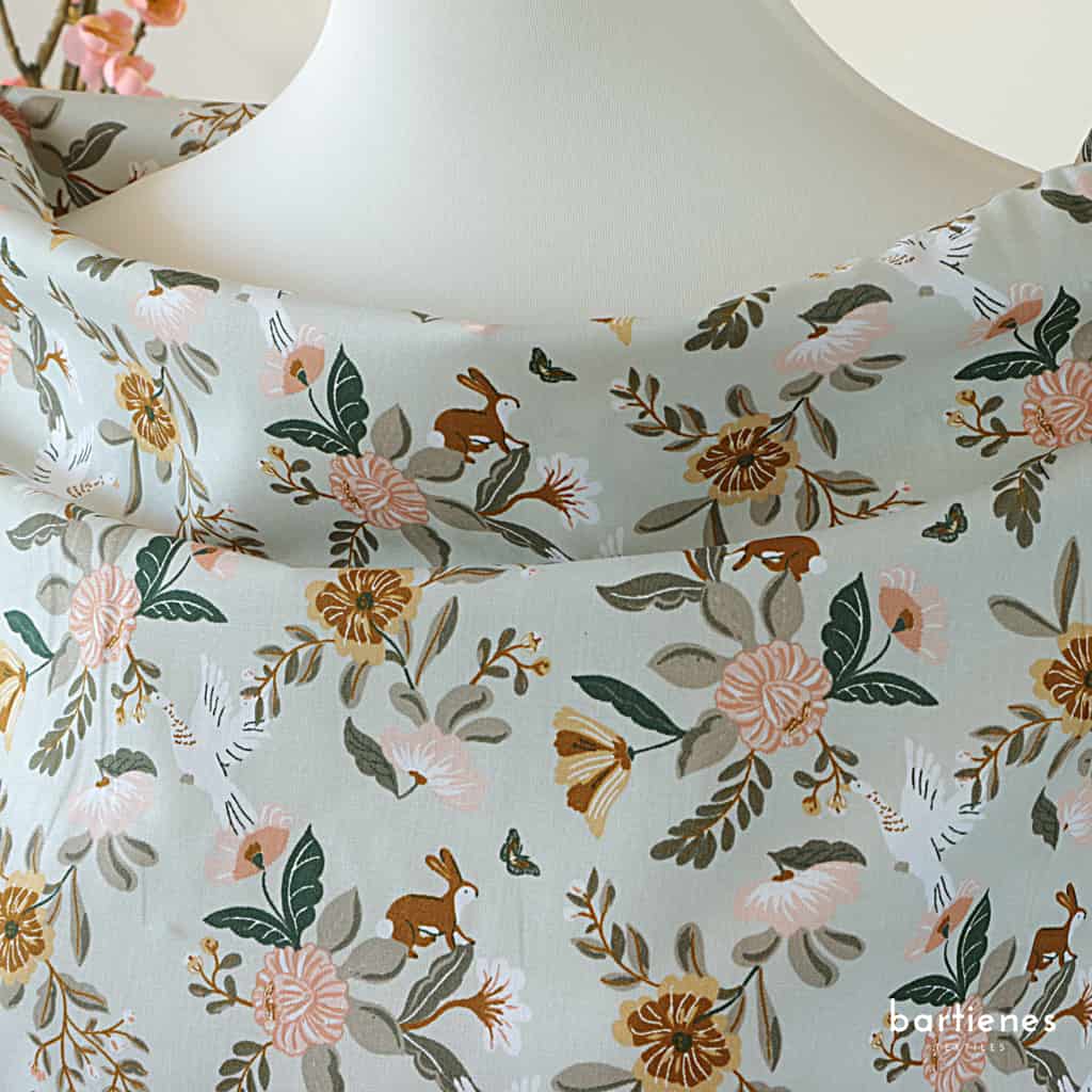 foto-von-bio-baumwoll-popeline-mit-verspieltem-muster-aus-blumen-und-hasen-in-zartem-gruen-grau