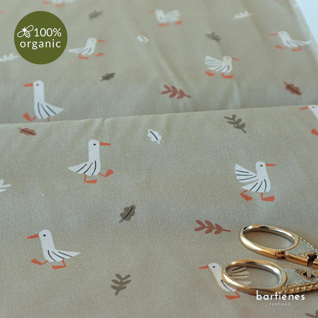 detail-von-bio-baumwollstoff-meterware-in-sehr-hellem-gruen-mit-niedlichen-gaensen-und-blaettern