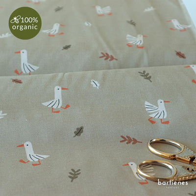 detail-von-bio-baumwollstoff-meterware-in-sehr-hellem-gruen-mit-niedlichen-gaensen-und-blaettern