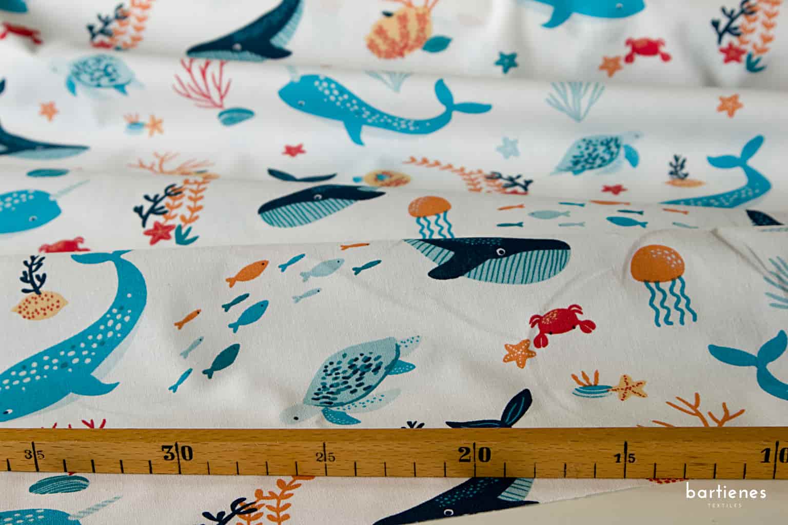 detail-von-kinderstoff-baumwolle-weiss-mit-walen-und-weiteren-meerestieren-mit-massstock-zur-einordnung-der-motivgroesse
