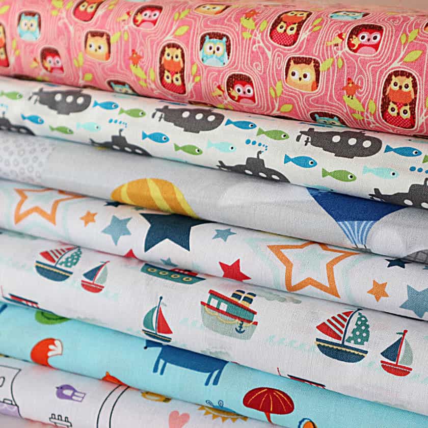 stoffballen-mit-fröhlichen-kinderstoffen-aus-fester-webware-mit-unterschiedlichen-kinder-motiven-als-sale-bild