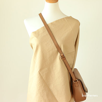 leinen-meterware-vorgewaschen-in-uni-beige-warm-sand-an-kleiderpuppe-damen-drapiert-mit-crossbody-ledertasche-hellbraun