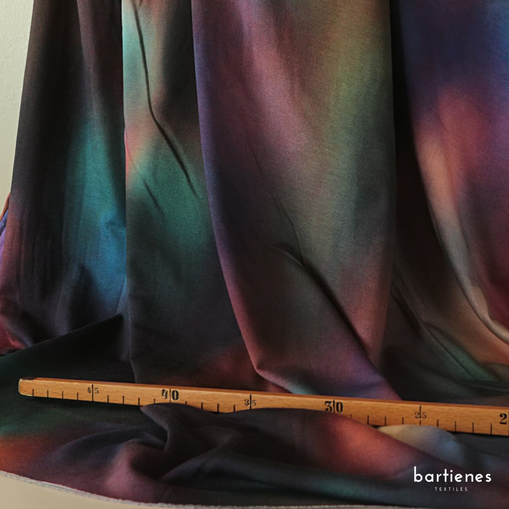 foto-von-lyocell-stoff-in-geheimnisvollen-dunklen-farbflächen-die-sanft-ineinander-fliessen-mit-massstock