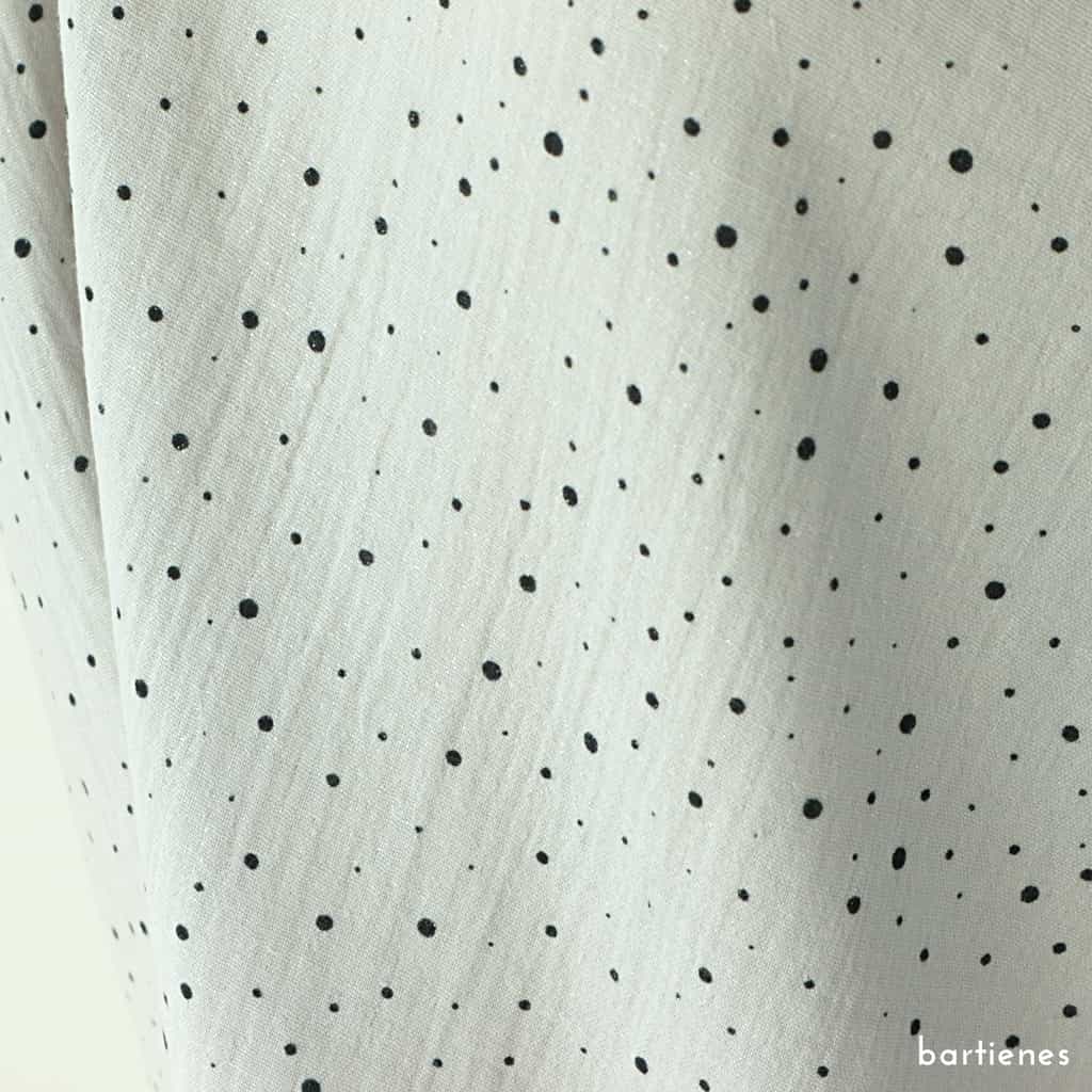 detail-von-double-gauze-meterware-in-silber-mit-schwarzen-unregelmässigen-mini-punkten-und-ganz-dezentem-glitzer