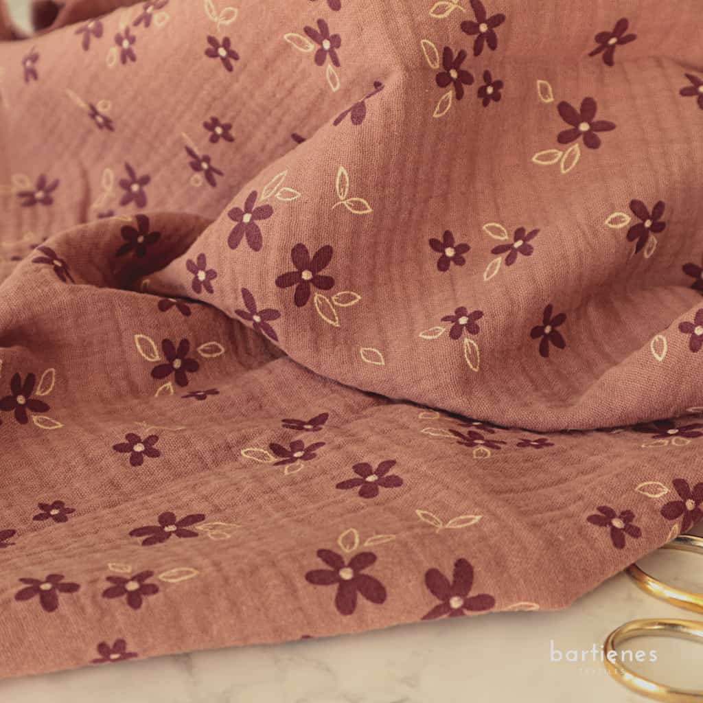 foto-von-musselinstoff-altrosa-braun-mit-kleinen-blumen-in-weinrot-auf-tisch-liegend