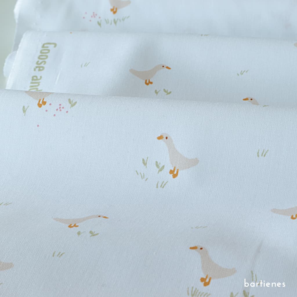 feine-baumwoll-popeline-mit-kindermotiv-kleine-gaense-und-blumen-auf-weiss