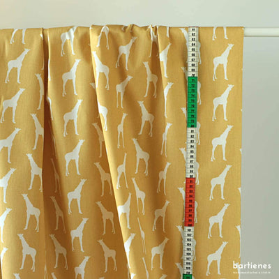 dekostoff-kinderzimmer-in-gelb-mit-grafischem-muster-giraffen-an-vorhangstange
