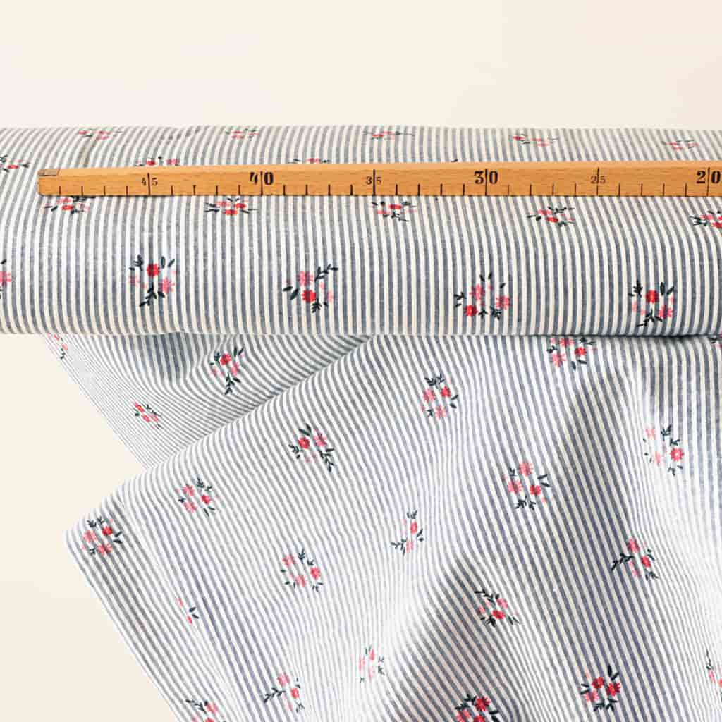 stoffballen-seersucker-mit-frischen-streifen-in-blau-weiss-und-mini-muster-aus-kleinen-blümchen-mit-massstock