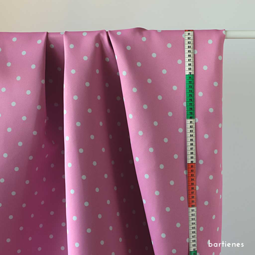 Verdunklungsstoff Meterware für Kinder in Pink mit Punkten in Weiss über Vorhangstange drapiert mit Massband